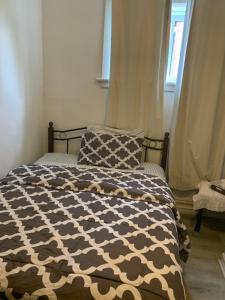 a bed with a black and white comforter and two pillows at Uottawa Private Room Meters away from Parliament Hill in Ottawa +32 photos