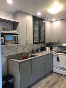 a kitchen with white cabinets and a sink at Victorian2 Henderson Héritage Home in Ottawa