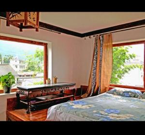 ein Schlafzimmer mit Bett, Schreibtisch und Fenster in der Unterkunft Dali Lily Guest House, close to the Honglongjing Gate of the ancient city,only 200 meters ,near the Cangshan and Erhai Lake,English-speaking service, convenient payment in Dali Ancient Town + 34 Fotos