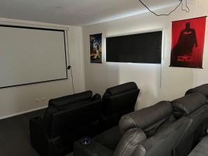 a living room with a black leather couch and a window at Countryside Retreat- DS Holiday Home in Carngham