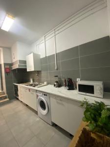 a kitchen with a washing machine and a dishwasher at Casa São Marcos in Peniche