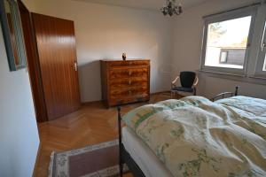 a bedroom with a bed and a dresser and a window at Ferien-Bungalow Wiesenweg in Timmendorfer Strand