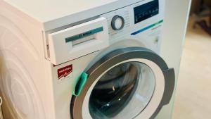 a white washing machine sitting in a room at CK Apartment in Oberhofen am Irrsee