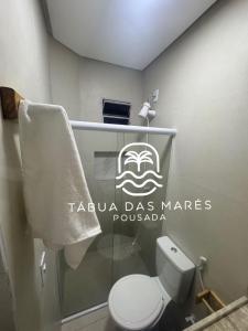 a bathroom with a toilet and a sign on the wall at Pousada Tábua das Marés in Japaratinga