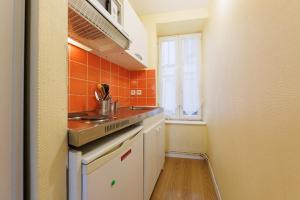 een kleine keuken met oranje tegels op de muur bij La Terrasse de Chamalières - Central - Wifi in Chamalières