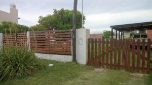 a wooden fence in a yard next to a house at Casa pali in Miramar