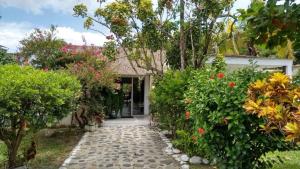 einen Gartenweg, der zu einem Haus mit Blumen führt in der Unterkunft Villa Mariela in Villeta