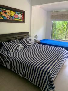 ein schwarz-weißes gestreiftes Bett in einem Schlafzimmer in der Unterkunft Villa Mariela in Villeta