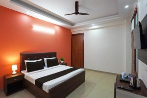 1 dormitorio con cama y pantalla de proyección en Hotel O Noida Stays, en Indirapuram