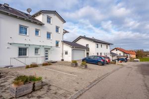 a car parked in a parking lot in front of a house at Ferienwohnungen Christoph in Pfaffing