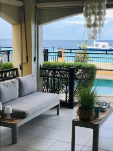 a patio with a couch and a view of the ocean at Luxury Oceanfront Elegancia in Kralendijk
