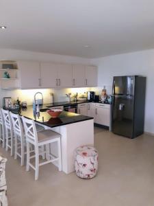 a kitchen with a black refrigerator and white cabinets at Luxury Oceanfront Elegancia in Kralendijk