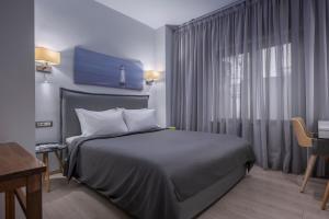 a hotel room with a bed and a window at Square Elegant Suites in Thessaloniki