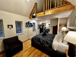 Un dormitorio con una cama con un gato sentado en ella. en Cozy Cabin Centrally Located Close To Walking Trails And Beaches!, en Ucluelet