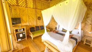 a room with two beds and a tv in a room at Elang Hillside Bamboo Villas in Labuan Bajo
