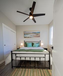 een slaapkamer met een bed met een plafondventilator bij Seal Pup Cottage in Ocean Shores