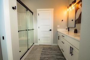 een badkamer met douche en glazen deur bij Seal Pup Cottage in Ocean Shores +34 foto's