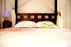 舍尔谢Vue sur Mer Caprices de l'Ombre的一张带两个枕头和木制床头板的床