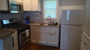 a kitchen with a white refrigerator and a sink at Cozy Texoma Guesthouse in Sherman