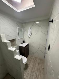 a white bathroom with a toilet and a shower at LA CASONA Finca Hostal in Apía +19 photos