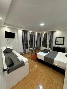 a bedroom with two beds and a table at LA CASONA Finca Hostal in Apía
