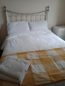 a bedroom with a bed with a blanket on it at Milton Keynes Lettings in Milton Keynes