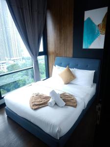 a bed with a teddy bear on it with a window at 8Pax Green View next to KL118 ChinaTown n Train Station in Kuala Lumpur