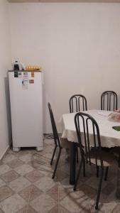 a kitchen with a table and a white refrigerator at Quarto de Hóspedes - Marambaia in Belém