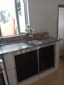a kitchen counter with a sink and a window at Casa completa Estância Turística de Ribeirão Pires in Ribeirão Pires