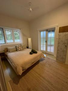 a large bedroom with a large bed with windows at The Strawberry Shed in Diamond Beach