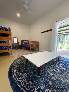 ein Wohnzimmer mit einem weißen Tisch und einem blauen Teppich in der Unterkunft The Strawberry Shed in Diamond Beach