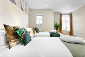 a white bedroom with two beds and a couch at Spacious London 2-Bed Flat with a King Bed-Save on Long Stays-5 Separate Beds- Parking Available! in Barnet