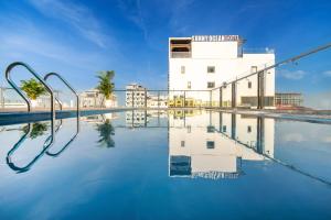 a swimming pool with a building in the background at Coral Cove Hotel in Danang
