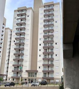 a tall building with cars parked in front of it at Apto da Fé in Cachoeira Paulista