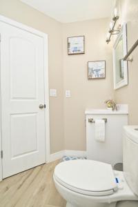 a white bathroom with a toilet and a sink at Near the Strip, Smart TVs, WiFi, private garage and backyard in Las Vegas +15 photos