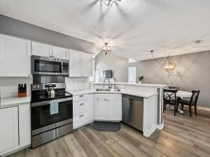 een keuken met witte kasten en een eetkamer bij The Paramour comfy home with ground floor bedroom and fenced in yard in Summerville +14 foto's