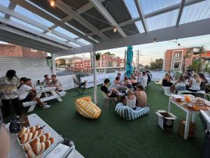 a group of people sitting on chairs under a roof at Little Coogee Hotel in Sydney