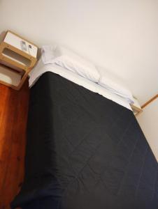 een bed in een kamer met een zwart dekbed bij Cabañas MoonRose in Concepción del Uruguay