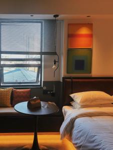 长沙Mcsrh Hotel-Changsha IFS and WUYI Plaza的卧室配有一张床和一张桌子,靠窗