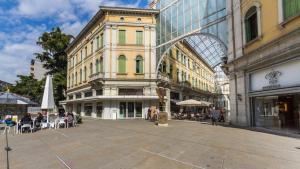 a large building with people sitting in chairs in a street at Matteotti Gallery Venice Apt in Mestre