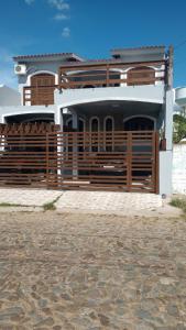 a house with a wooden fence in front of it at pousada do cleo in São Gabriel