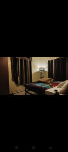 a bedroom with a bed and curtains in a room at Shivalaya cottage,Home away from home,mehragaon,bhimtal in Bhowāli