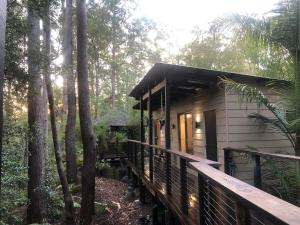 a small house in the woods with a wooden porch at Earthly Retreat - Private Noosa Hinterland Getaway in Doonan