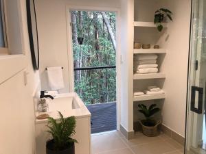 a bathroom with a sink and a window with towels at Earthly Retreat - Private Noosa Hinterland Getaway in Doonan