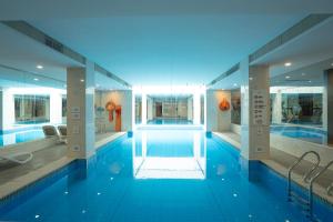 a large swimming pool with blue water in a building at Tonino Lamborghini Hotel Suzhou in Suzhou