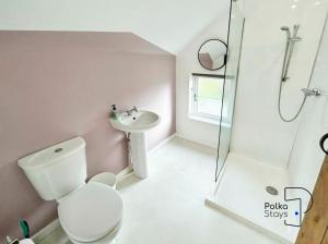 a bathroom with a toilet and a sink and a shower at Hên Stablau - Spacious Pet-Friendly Welsh Retreat by PolkaStays in Llanfihangel-Glyn-Myfyr +16 photos