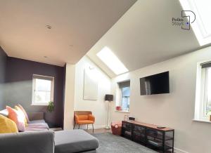 a living room with a couch and a tv at Hên Stablau - Spacious Pet-Friendly Welsh Retreat by PolkaStays in Llanfihangel-Glyn-Myfyr