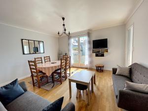 a living room with a table and a dining room at Maison avec jardin près de la mer - FR-1-361-560 in Donville-les-Bains