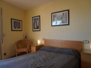ein Schlafzimmer mit einem Bett und einem Stuhl sowie Bildern an der Wand in der Unterkunft Medas Park 253 - L'Estartit, Centro - ES-323-90 in Torroella de Montgrí + 19 Fotos