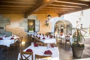 a restaurant with white tables and chairs in a room at Hotel Larrañaga in Azpeitia